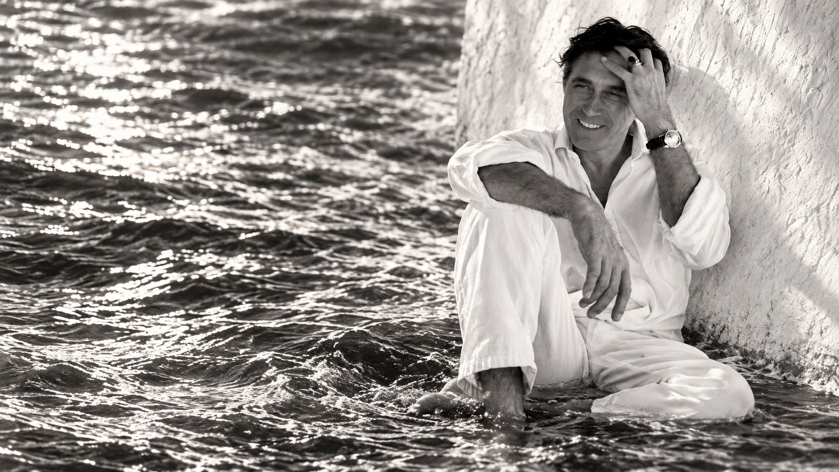 Bryan Ferry au bord de l’eau, en noir et blanc, dans une atmosphère élégante et mélancolique.