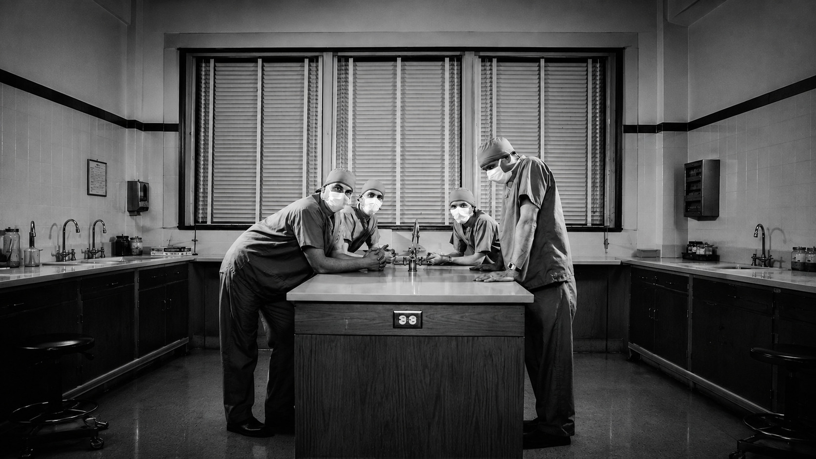 Clinic en tenues médicales dans une pièce clinique en noir et blanc.