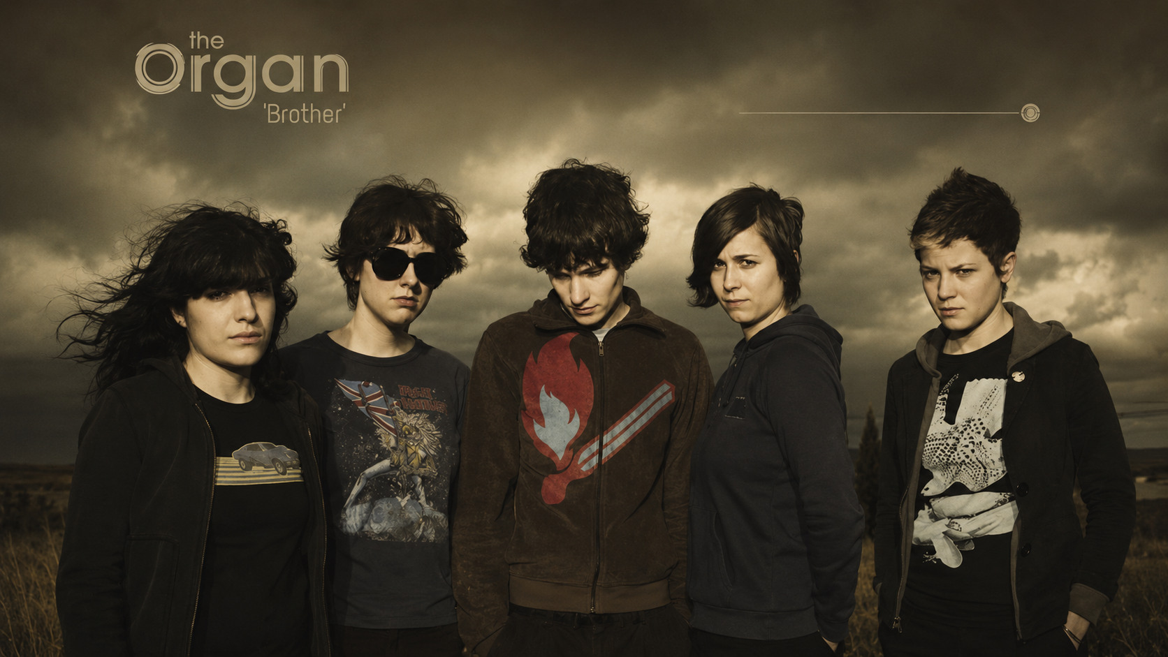 The Organ, portrait de groupe dans un paysage sombre et nuageux.