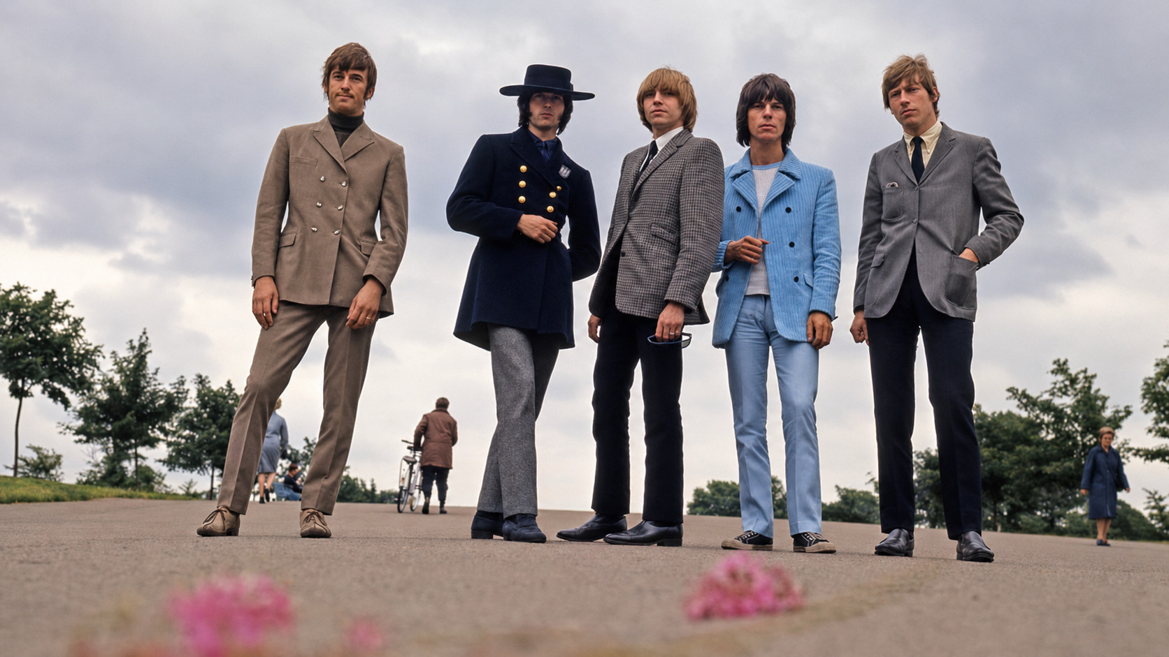 The Yardbirds en tenue sixties dans un parc sous un ciel couvert.